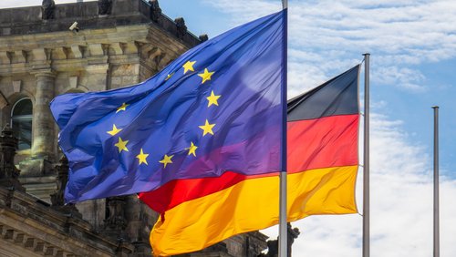 Flaggen der EU und Deutschland wehen im Wind vor dem Reichstag in Berlin.