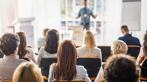 Back view of large group of business people having a training class in a board room. Back view of large group of business people having a training class in a board room.