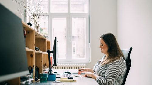 Mitarbeiterin Öffentlicher Dienst am Desktop-Computer arbeitend.