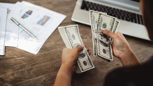 Buchhalterin zählt Dollar-Banknoten für finanzielle Geschäftskonzepte.