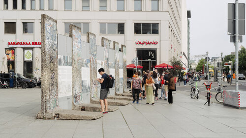 Touristen, die sich in Berlin die Reste der Mauer anschauen
