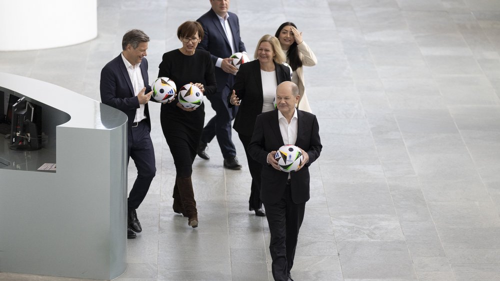 Bundeskanzler Scholz und weitere Kabinettsmitglieder bei einem Fototermin vor der Heim-EM. Konjunkturell wird das Ereignis ein torloses Unentschieden. 