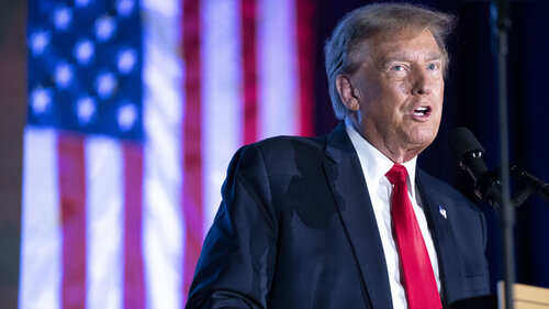 Der ehemalige US-Präsident Donald Trump hält eine Rede. Im Hintergrund ist die amerikanische Flagge zu sehen. 