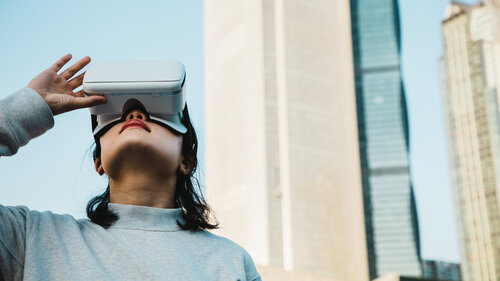Woman using Virtual Reality headset in the cityscape