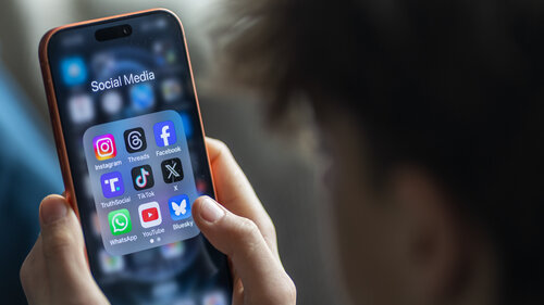 BATH, UNITED KINGDOM - MARCH 29: In this photo illustration a 14-year-old boy holds an iPhone screen displaying various social media and messaging apps on March 29, 2026 in Bath, England. On top row left to right, the logo of social media platform Instagram is seen beside that of Meta’s Threads and Facebook. On the middle row from left is the logo of Donald Trump's Truth Social app, next to the logo of social media app TikTok and the logo of Elon Musk’s US online social media and social networking site 'X' (formerly known as Twitter). Along the bottom row, left to right is the messaging service WhatsApp, the logo for online video sharing and social media platform YouTube and the logo for the Bluesky app. In the UK, a ban on social media for under-16s has been backed by the House of Lords following the Australian law which aims to stop children under 16 from having social media accounts and social media platforms, including TikTok, Facebook, Snapchat, Reddit, X, formerly Twitter, and Instagram potentially being be fined for preventing children younger than 16 from having social media accounts. (Photo by Anna Barclay/Getty Images)