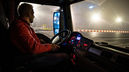 The driver at the wheel of the truck. The driver at the wheel of the truck.