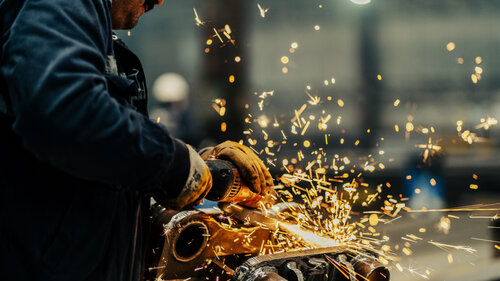 Metal worker using a grinder Metal worker using a grinder