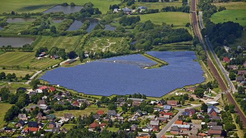 Aerial view over photovoltaic power station / solar park for the supply of merchant power into the electricity grid, Germany