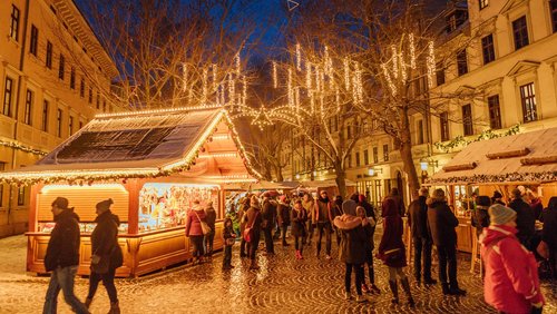 Weihnachtsmarkt im Dunkeln, mit hell beleuchteten Ständen