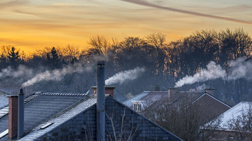 Smoking domestic rooftop chimneys from houses emitting vapour