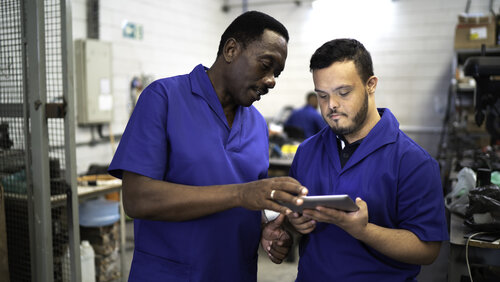Colleagues using digital tablet and working in industry