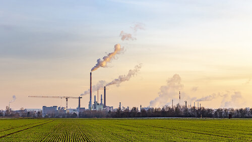 industry complex in Frankfurt in late evening with fields and smoking chimney industry complex in Frankfurt in late evening with fields and smoking chimney