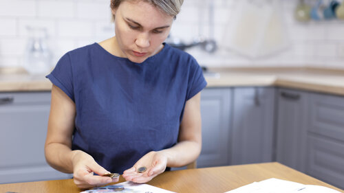 Eine blonde Frau hält Münzen in den Händen, zählt Geld. Eine blonde Frau hält Münzen in den Händen, zählt Geld.
