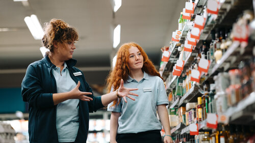 Supermarket manager giving training to a trainee employee