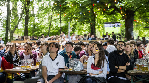 Deutsche Fußballfans sitzen in einem Biergarten beim Public-Viewing