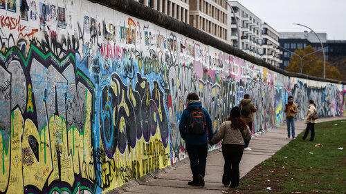 Menschen besichtigen die Reste der Berliner Mauer