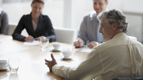 Geschäftsleute der Babyboomer-Generation bei einer Tagung im Konferenzraum.