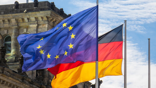 Flaggen der EU und Deutschland wehen im Wind vor dem Reichstag in Berlin.