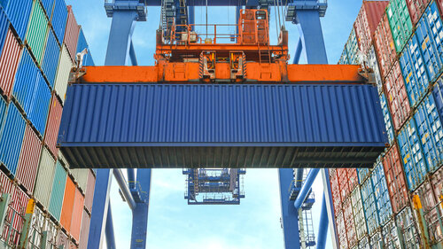 Shore crane loading containers in freight ship