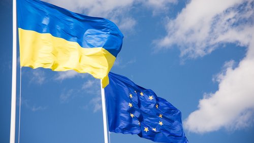 Flaggen der Ukraine und der Europäischen Union (EU) mit blauem Himmelshintergrund