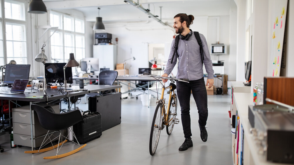Businessman with a bicycle in office. Business professional going home after work. Businessman with a bicycle in office. Business professional going home after work.
