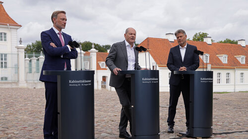 Lindner, Scholz und Habeck sprechen nach ihrer Kabinettsklausur vor dem Hintergrund von Schloss Meseberg zur Presse.